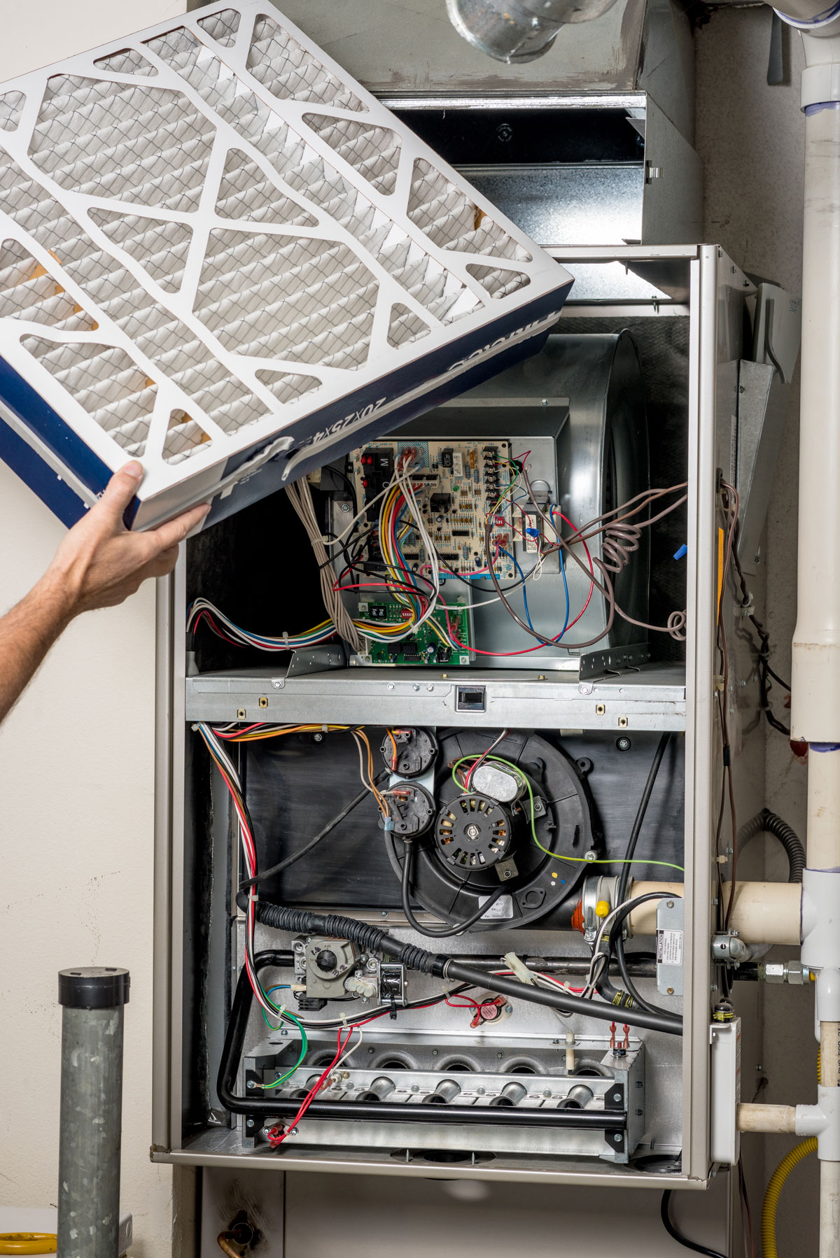 Man replacing a filter in an open furnace